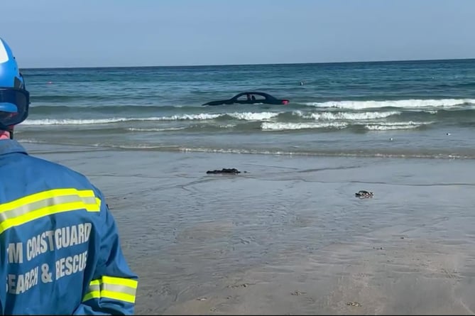 Video grab as footage shows a convertible BWM washed out to sea after parking on the beach with the coastguard joking: You cant park there! The vehicle believed to be a E93 soft top was filmed off Trevaunance Beach, Cornwall, this morning (Sun). See SWNS story SWMRcar. St Agnes Coastguard Search & Rescue Team said they were called to the beauty spot at around 8.30am, where they first made sure there was no one in the car.Their teams then remained on scene whilst recovery efforts took place, before the flashy sports car was finally removed by a tow truck off the beach.
