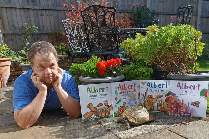 Ian Brown with his books and Albert the tortoise