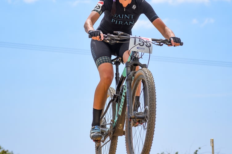 Jenny Bolsom on her mountain bike wearing Saint Piran kit, a helmet and sunglasses. In the photo, her bike is up in the air above the gravel track below as she has just ridden over a bump.
 
Jenny Bolsom from Truro has been selected as one of Cycling UK's 100 Women in Cycling announced on Thursday 23 November.
 
Every year the 100 Women in Cycling list celebrates inspirational women who are encouraging others to experience the joy of cycling.
 
Jenny Bolsom has been nominated as a sporting hero for her work as a Manager of Saint Piran Women Race Team.
