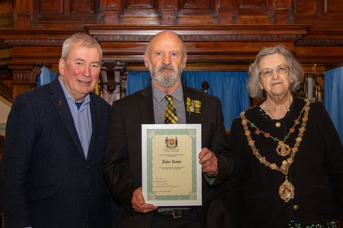 John Rowe receives his award from Malcolm Bell and  Cllr Carol Swain 