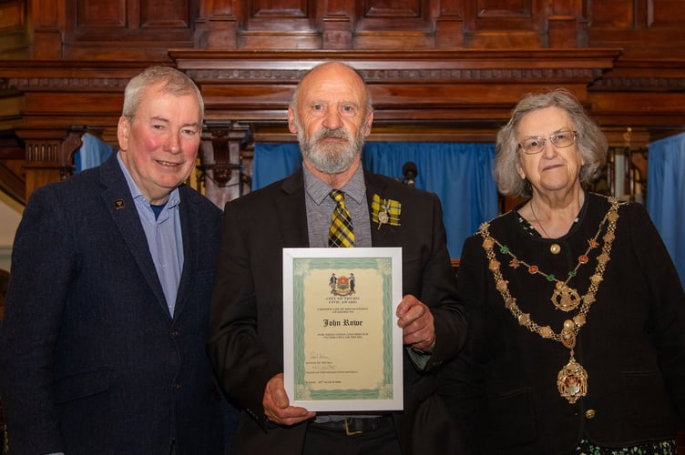 John Rowe receives his award from Malcolm Bell and  Cllr Carol Swain 