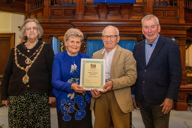 Godfrey and Peggy Mortimore receive their award from Cllr Carol Swan and Malcolm Bell