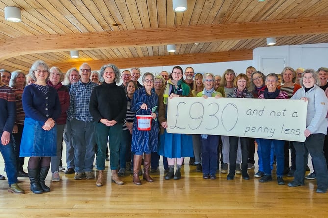 The Suitcase Singers present a cheque for £930 to ShelterBox