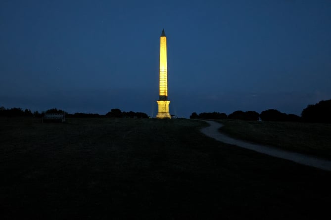 The Bodmin Beacon memorial obelisk lit up yellow