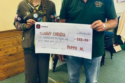 Brownie Pippa gives cheque to Sunny Corner