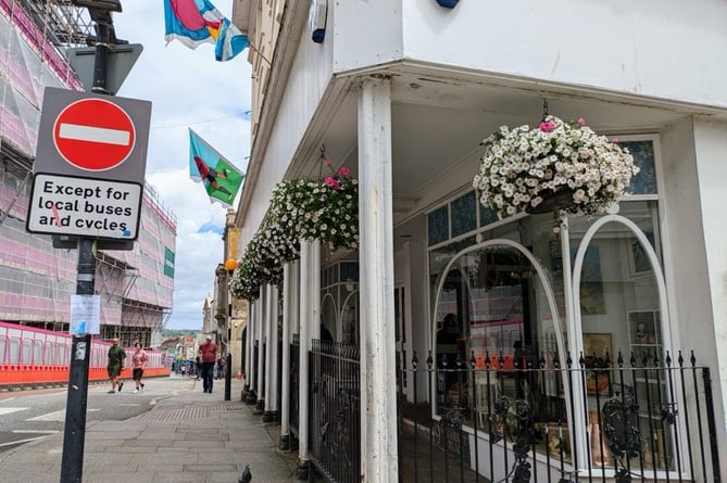 Hanging baskets in full bloom outside a shop at the top of Market Jew Street (Photo- Pz Community Flora Group)