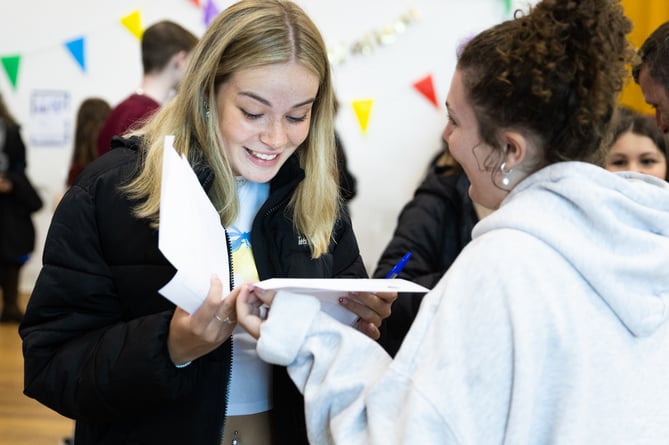 Emily R proudly holds up her results, ready to embrace new challenges and opportunities