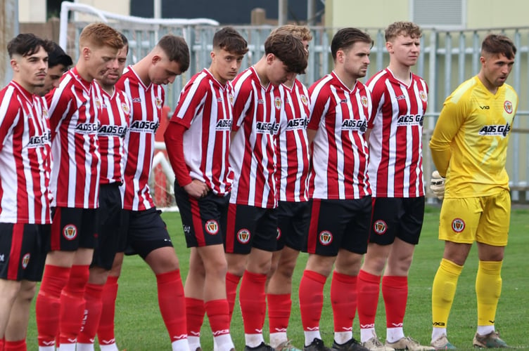 Saltash's players observe a minute's silence in memory of club legend Gary Carew who passed away recently, before Saturday's clash with Wellington. Picture: Daz Hands Photography