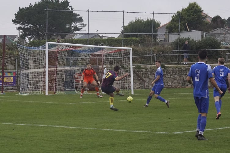 Charlie Edney slots home Wendron United's third goal to put the Dron 3-2 up against Liskeard Athletic at Underlane on Saturday. Picture: Dave Deacon