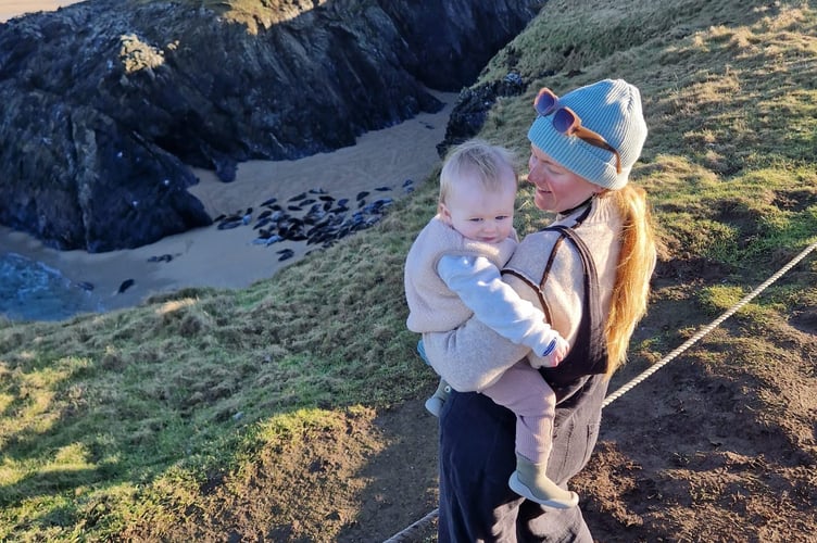 Imogen Toulson with her daughter where they spotted seals  playing on remote Cornwall beach near St Austell, January 15, 2025. A woman was left stunned after stumbling across more than 60 seals resting and playing on a secluded beach in Cornwall. Imogen Toulson, 30, was on a walk when she saw dozens of seals at a hidden cove along the coast path from Poll Joke Beach, near St Austell (Jan15, 2025).  Seals are known to visit the area at low tide, but she was amazed by the sheer number gathered on the sand and in the water. Imogen, a stay-at-home mum, from Cornwall, UK said: âIt is normal to see seals here under the right conditions but I was shocked to see so many.  "There had to be at least 60 on the sand and even more in the ocean.